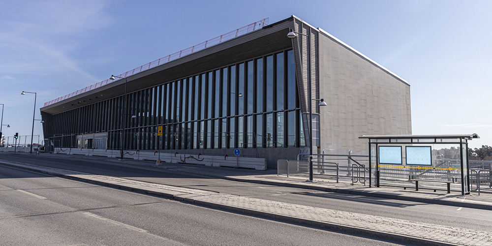 Grå byggnad med stort glasparti.