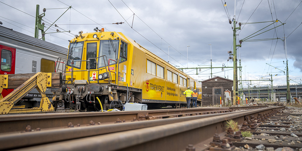 Gult tåg står på banvall.