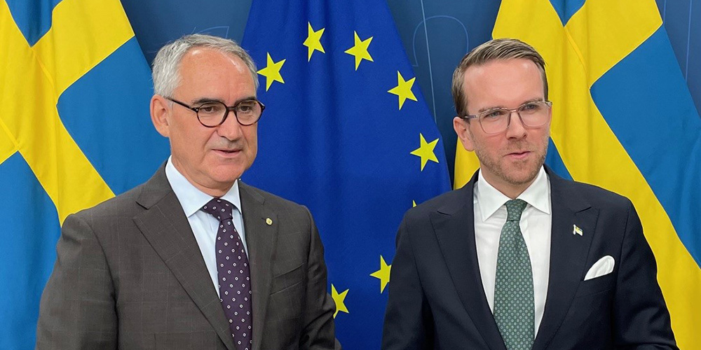 Roberto Maiorana och Andreas Carlson. framför Sverigeflagga och EU-flagga.
