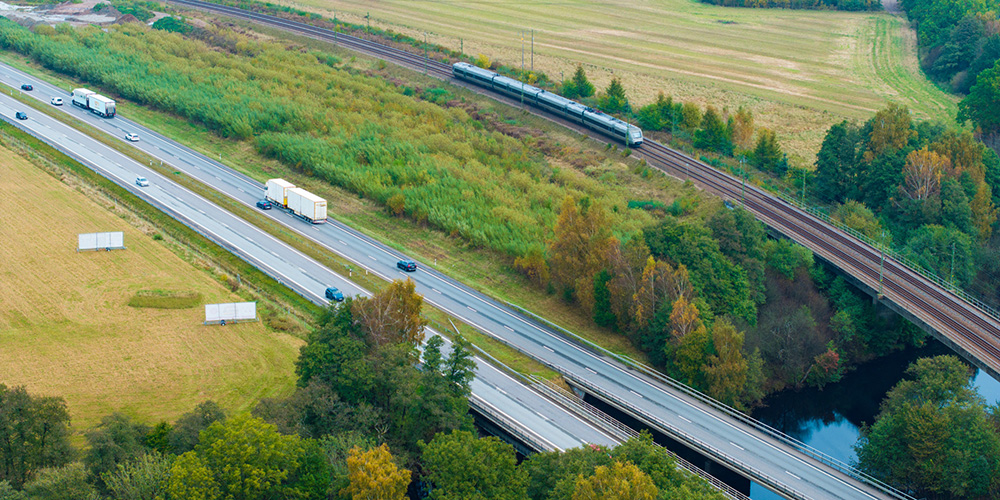 Järnväg och mötesfri väg går parallellt över vattendrag.
