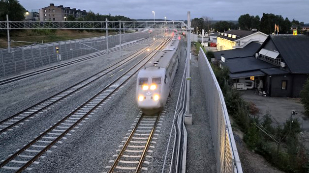 Ett persontåg på räls som närmar sig kameran