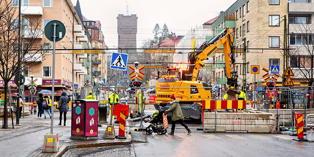 Grävmaskin gräver i stadsmiljö.